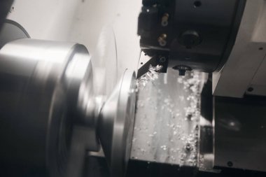 CNC torna makinesi ya da dönen makine çelik şaftta parçalar kesiyor. Bilgisayar Sayısal Kontrol Tornası 'ndaki elementler kesiliyor. CNC tarafından üretilen kalıp ve ölüm süreci