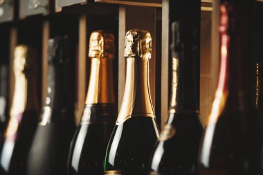 Raflarda elit köpüklü şarap ile yeraltı mahzeni, yatay fotoğraf kapatın. Farklı pahalı alkollü içecekler ile arka plan