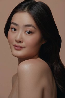 Bej arka planı, yüz bakımı, yüz bakımı, kozmetoloji, güzellik ve kaplıca gibi temiz ciltleri olan Asyalı güzel bir kadının stüdyo fotoğrafı..