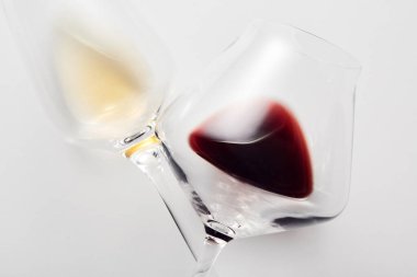 Kırmızı, beyaz şarapla dolu çaprazlanmış iki şarap kadehinin yakın görüntüsü. Tatil kutlaması, randevu, yıldönümü, alkollü içkilerle romantik buluşma. Stüdyo çekimi.