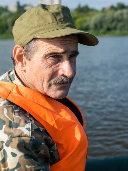 Balıkçı Nehri üzerinde bir tekne içinde oturur