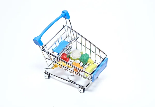 Beyaz arka planda ürünleri olan bir süpermarketten mini market arabası. Üst görünüm.