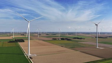Flevoland Hollanda 'da güneşli bir günde sürdürülebilir enerji üreten rüzgar türbinleri.