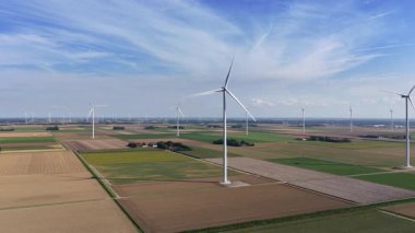Flevoland Hollanda 'da güneşli bir günde sürdürülebilir enerji üreten rüzgar türbinleri.