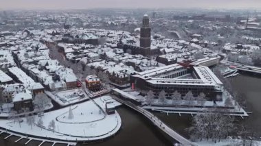 Zwolle Peperbus kilise kulesi soğuk bir kış sabahında şehir merkezindeki karla kaplı çatıların üzerinde yükseliyor..
