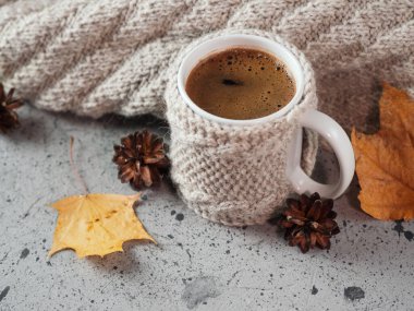 Masanın üzerinde örgü bir süveter ve yün bir eşarp olan bir kupa kahve. Soğuk sonbaharda ya da kışta Sabah Kahvaltısı