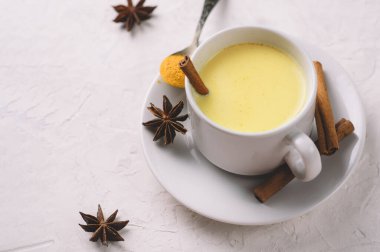 Beyaz bir masada tarçınlı altın zerdeçal sütü.