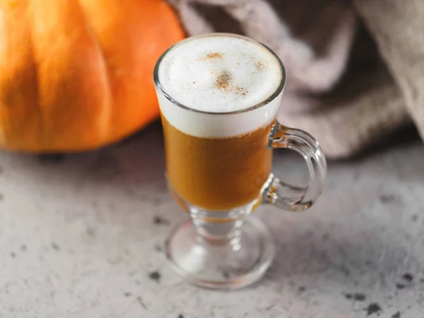 秋天南瓜拿铁杯子 一个温暖的饮料和一条针织围巾在灰色的桌子上 感恩节 — 图库照片