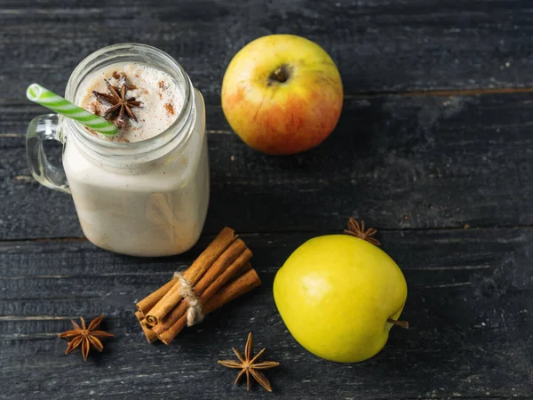 Apple smoothie with cinnamon on wooden table