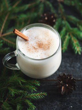 Eggnog Noel içeceği masada tarçın ve ladin dallarıyla