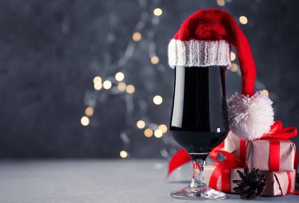 Bir bardak koyu renkli bira, Noel Baba şapkalı hamal uzay tatil masasında.