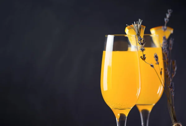 Siyah arka planda portakal suyu ve şampanya ile Mimosa içkisi