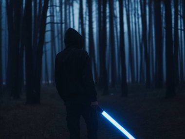 Karanlık sisli bir ormanda, elinde parlayan bir neon fener olan bir adam. Film tonlu seçici yumuşak odak
