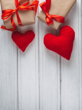İkisi için iki hediye ve tahta bir masada iki kırmızı kalp.