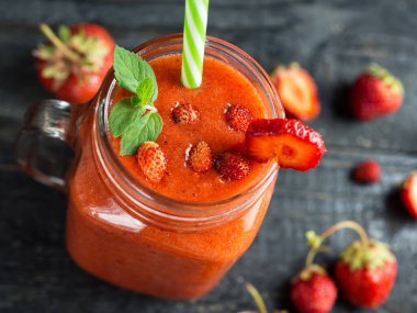 Çilekli kırmızı smoothie yakın çekim. Kırmızı dutların doğal yaz tatlısı