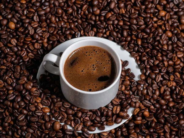 Close Van Een Witte Espressobeker Een Tafel Met Veel Koffiebonen — Stockfoto