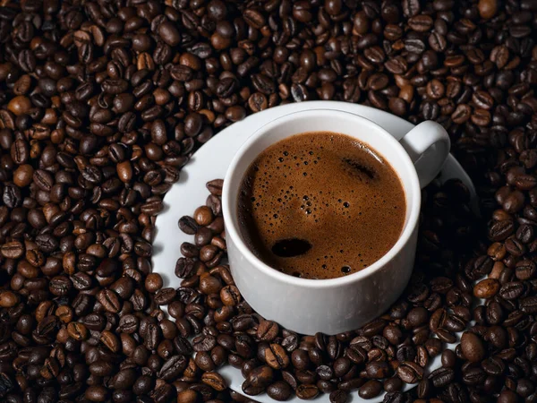 Close Van Een Witte Espressobeker Een Tafel Met Veel Koffiebonen — Stockfoto