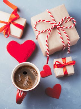 Bir fincan sıcak kahve, kırmızı kalpler ve Sevgililer Günü için bir hediye. Romantik sabah