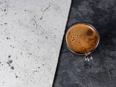 A Cup of espresso on a two-tone concrete background