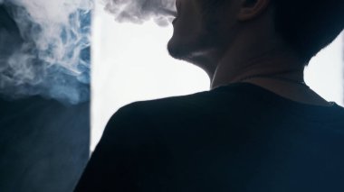Vape adam yakın çekim bir buhar bulutu üretir