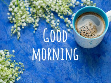 Bir fincan kahve ve bir buket vadi zambağı mavi arka planda üzerinde 