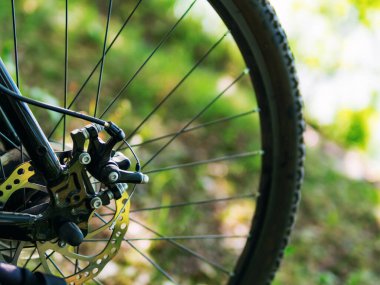 Yeşil zemin üzerinde disk freni olan 29 inç dağ bisikleti tekerleğinin yakın çekimi