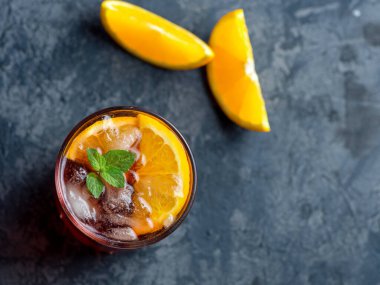 Koyu taş masada portakallı Negroni kokteyli. Kopyalama alanının üst görünümü