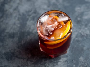 Koyu taş masada portakallı Negroni kokteyli. Kopyalama alanının üst görünümü