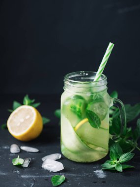 Salatalık, nane ve limonla detoks suyunu kavanoza koy. Soğuk yaz içeceği.