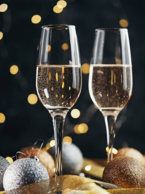 Karanlık bir arka planda şampanya bardaklarının yakın çekimi. Noel 'i ve yeni yılı kutla