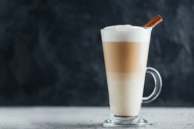 Beton bir masada tarçınlı bir bardak kahve.