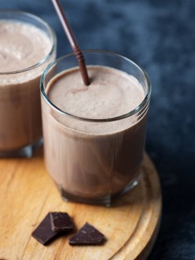 Koyu taş bir masanın üzerinde çikolata kokteyli bardağı.