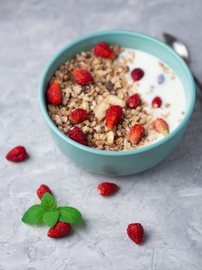 Bir fincan yoğurtlu müsli ve bademli çilek.