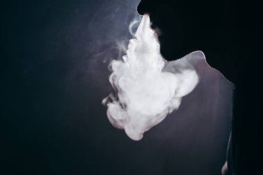 Yakın plan. Elektronik sigara kullanarak duman veya buhar soluyan genç bir adam. Mekanik buhar modu