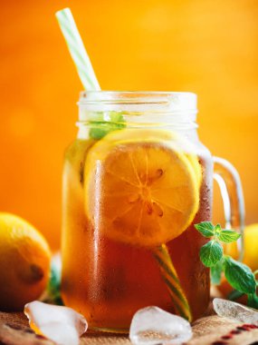 Soğuk yaz çayı, limon ve nane şekeri ile ahşap bir masada.