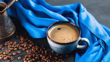 Bir fincan aromatik kahve, kavrulmuş kahve çekirdeği. Güzel mavi kupa ve jezva