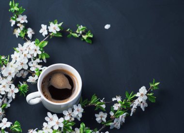 Baharda açan çiçeklerle kokulu bir fincan kahve. Boşluğu kopyala.