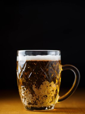 Siyah arka planda bir kupa light bira.