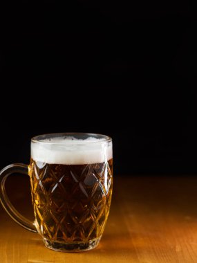 Siyah arka planda bir kupa light bira.