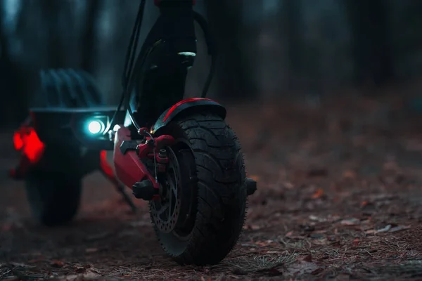 Akşamları elektrikli scooter 'la park ışıkları açıkken. Motor tekerleğine yakın çekim