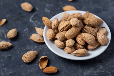 Koyu bir masada kavrulmuş tuzlu badem.