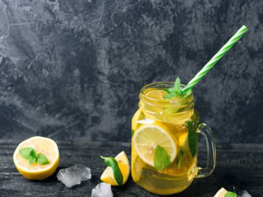 Cam kavanoz soğuk limonata ya da limonlu mojito, nane, çay ve buz koyu ahşap bir masada.
