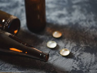 Masaya boş bira şişeleri ve kapaklar. Alkolizm