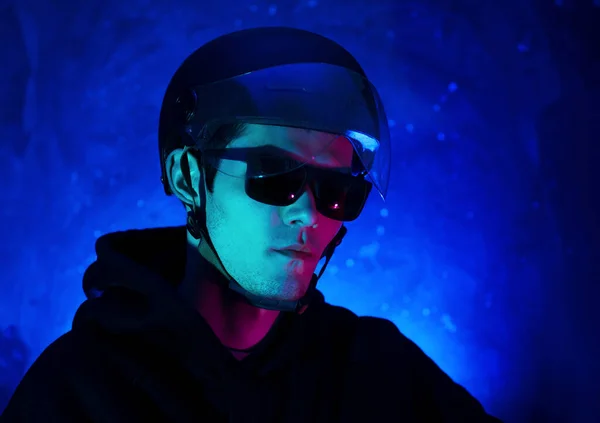 Rider in helmet with visor, sunglasses, colored neon portrait