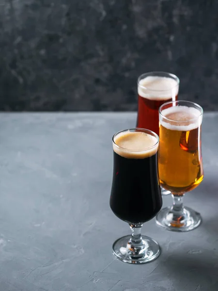 Drie Glazen Bier Verschillende Bierstijlen Pilsner Lager Stout Donkergrijze Achtergrond — Stockfoto