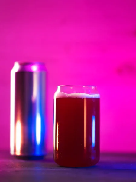 ビールの形をした創造的なガラスができます 明るいネオンの背景に赤いフルーツビールを作る アルミニウムビールができます — ストック写真