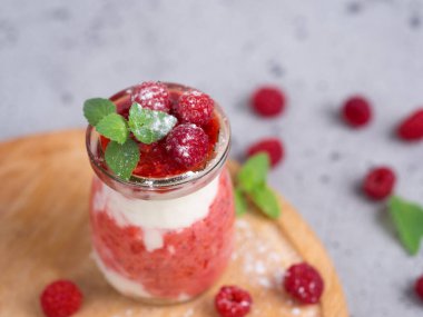 Ahududu soğuk yaz kremalı tatlı parfe gri bir masada naneli