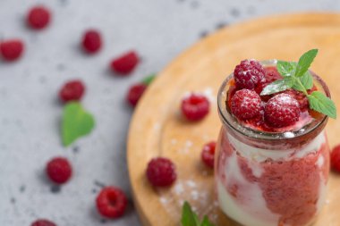 Ahududu soğuk yaz kremalı tatlı parfe gri bir masada naneli