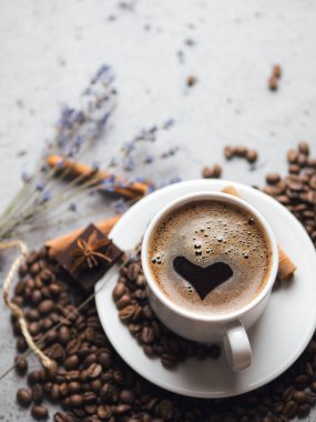 Tarçınlı ve anason kahve çekirdekli gri bir masada bir fincan espresso. Metin için boşluk olan üst görünüm