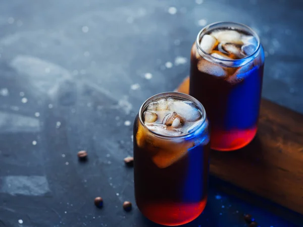 Dois Copos Elegantes Café Frio Luz Azul Colorida Uma Placa — Fotografia de Stock